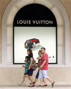 Một gia đình đi qua cửa hiệu Louis Vuitton ở khu mua sắm sang trọng Tràng Tiền Plaza, Hà Nội, ngày 19.7.2013. REUTERS/Kham