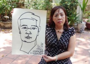 Nguyen Thi Duong Ha holds a self-portrait by her husband Cu Huy Ha Vu in May 2013 shortly before he began his hunger strike. Photo courtesy of Nguyen Thi Duong Ha