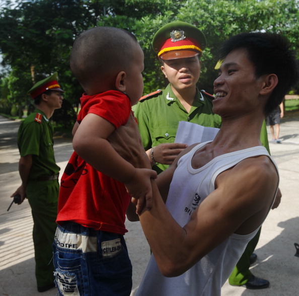 Một người vừa được trả tự do ôm đứa con của mình trước cổng trại giam Hoàng Tiến. (Ảnh Đinh Hoàng Nam AFP)